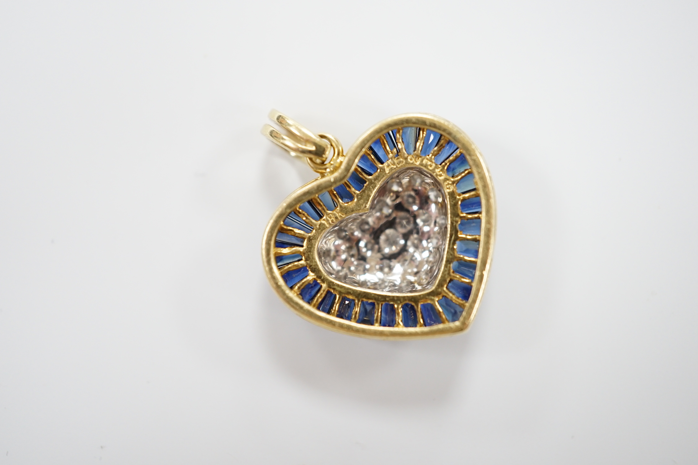 A modern 18k, pave set sapphire and diamond heart shaped pendant, overall 25mm, gross weight 4.9 grams.